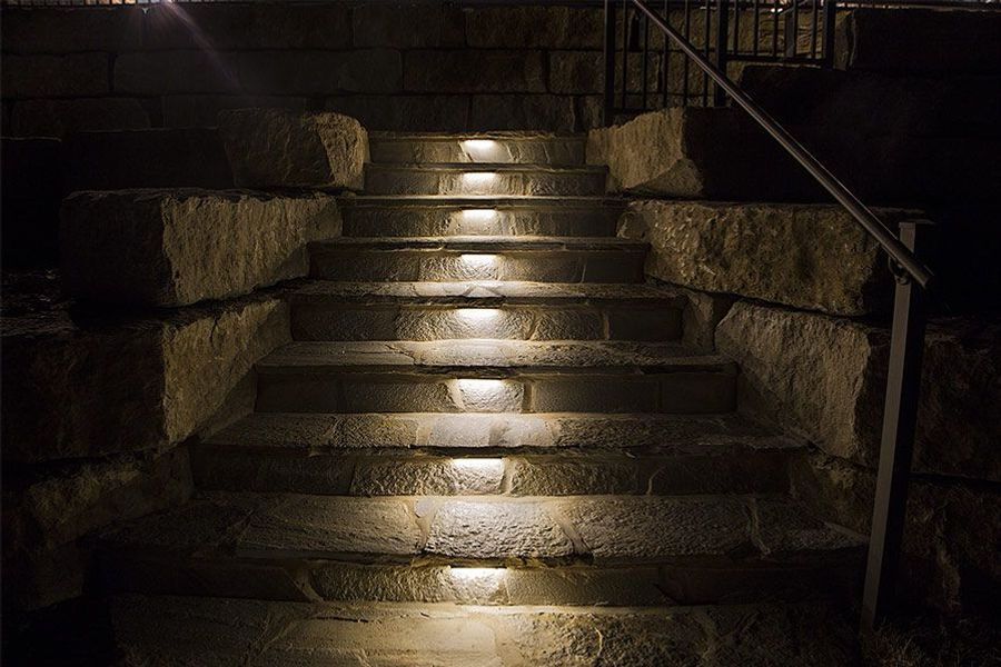 A set of stairs that are lit up at night.
