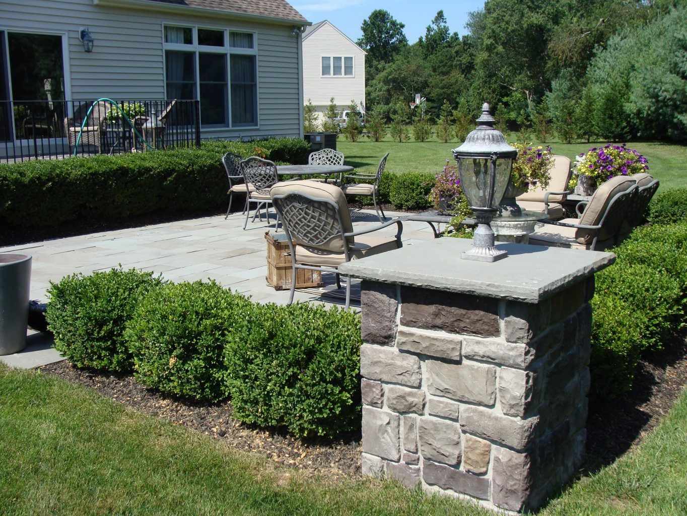 A stone pillar is in the middle of a patio area