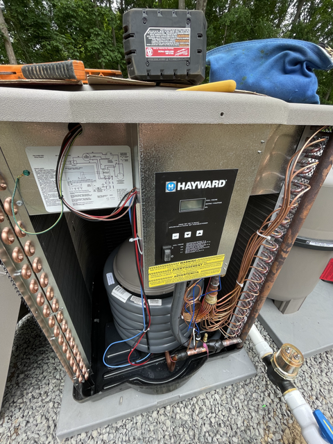 A pool heater is being repaired by a technician.