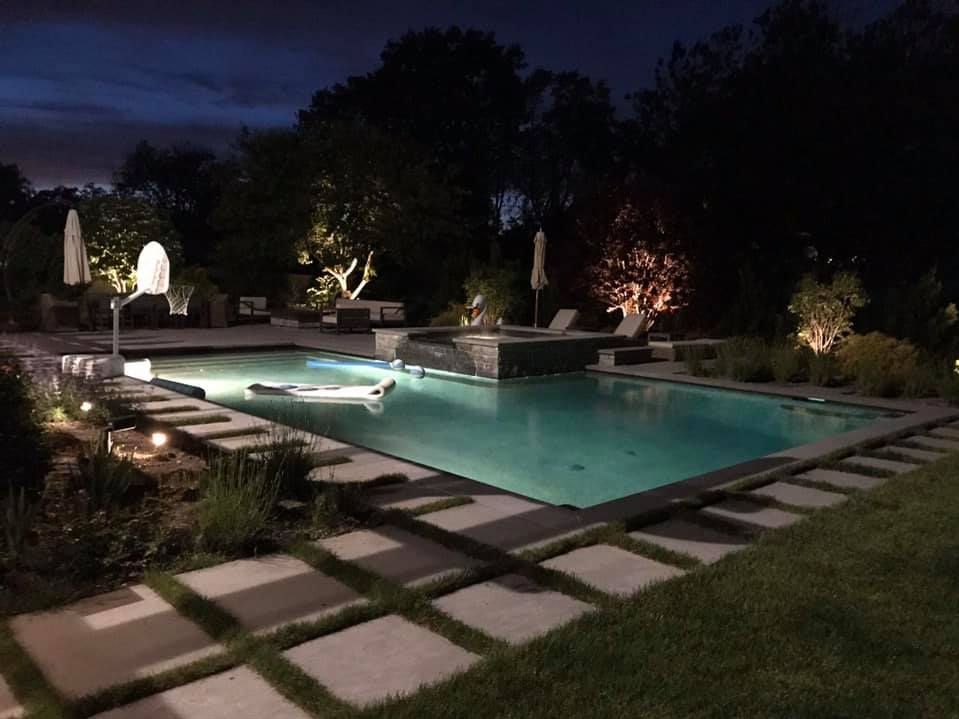 A large swimming pool is lit up at night