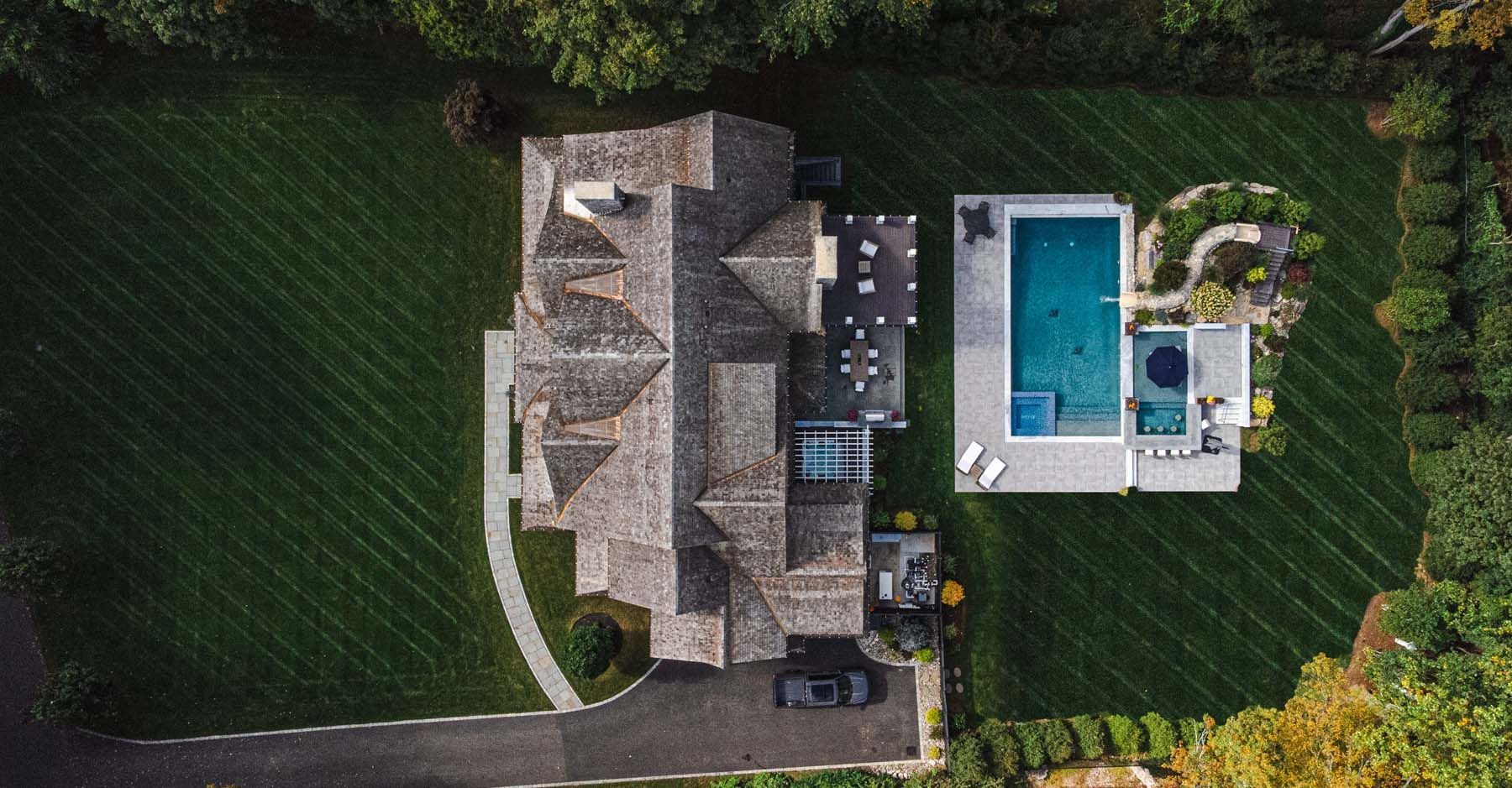 An aerial view of a house with a large pool in the backyard.