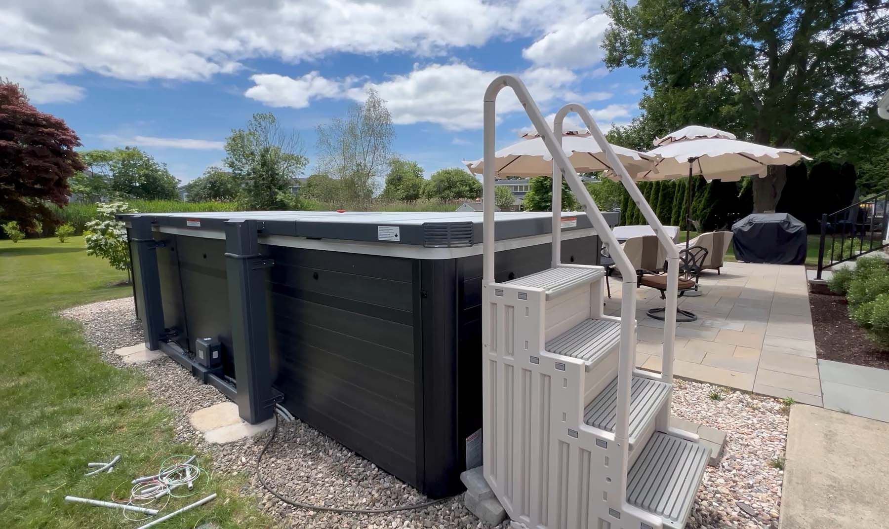 A large swimming pool with stairs leading up to it in a backyard.