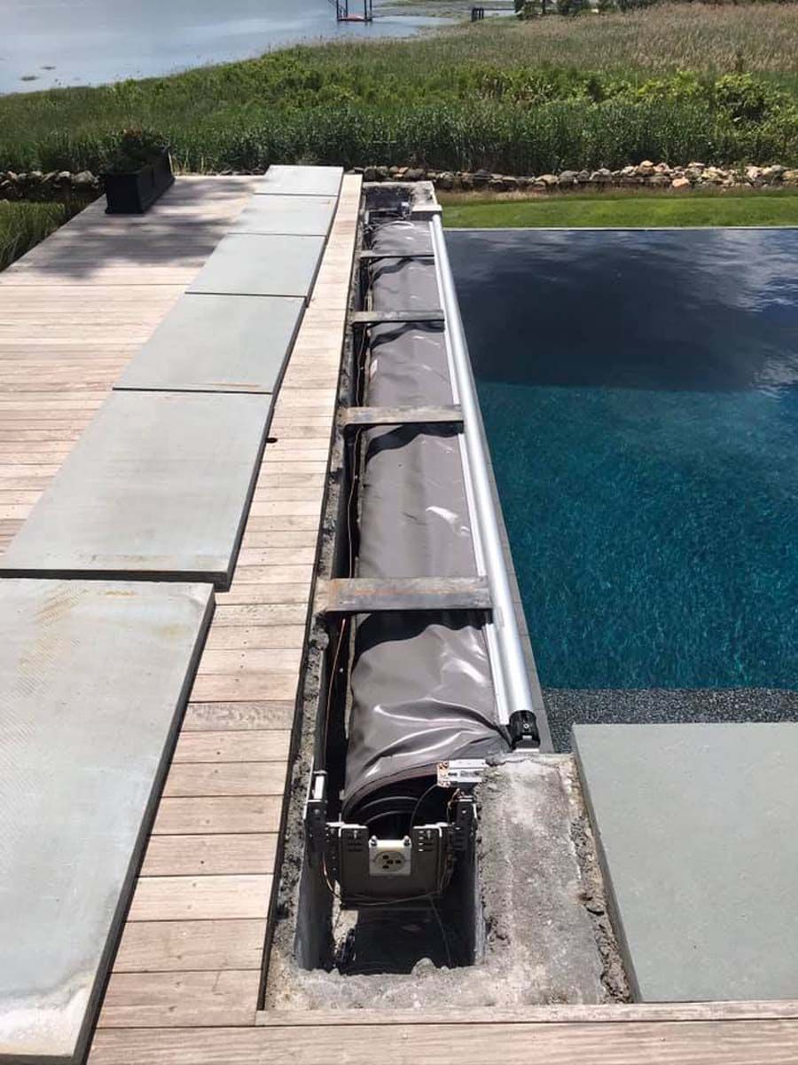 A swimming pool is being built next to a wooden deck.