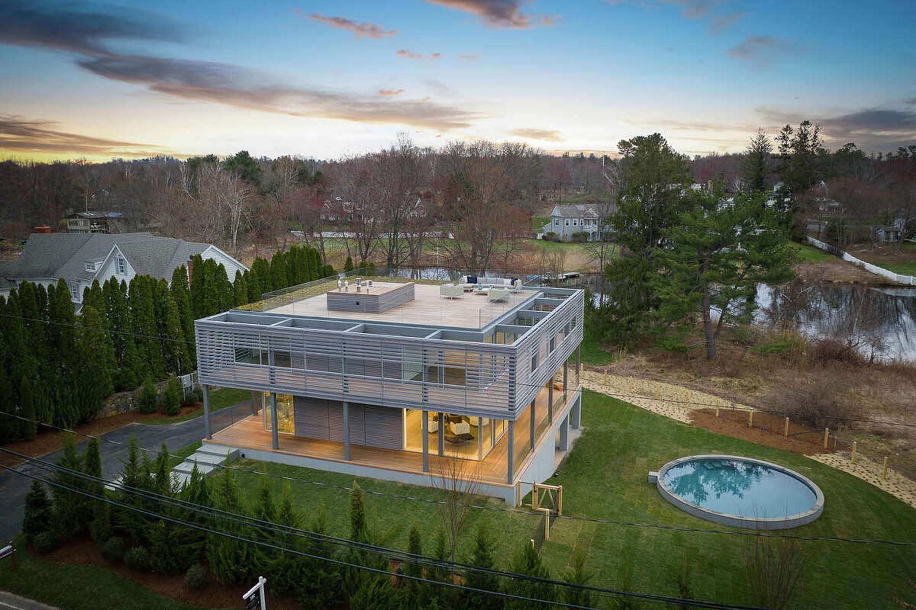 An aerial view of a modern house with a pool in the backyard.