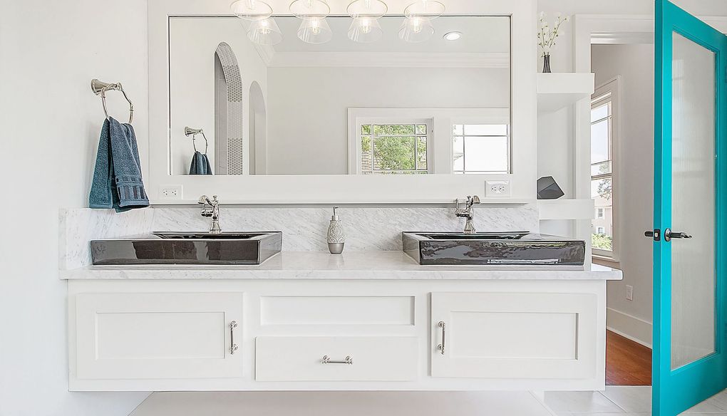 Modern white bathroom vanity with dual sinks, large mirror, and a turquoise door.