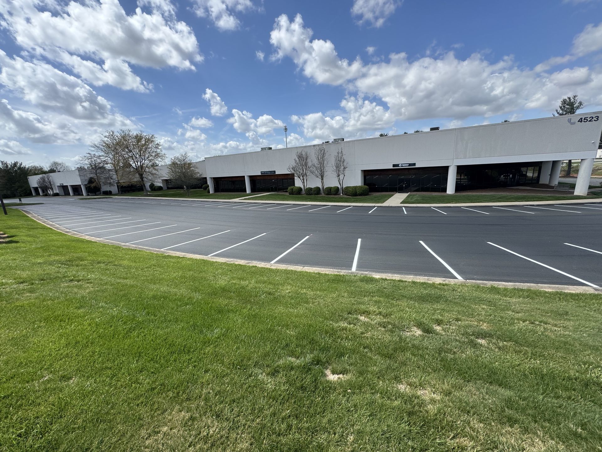 A large white building with a parking lot in front of it.