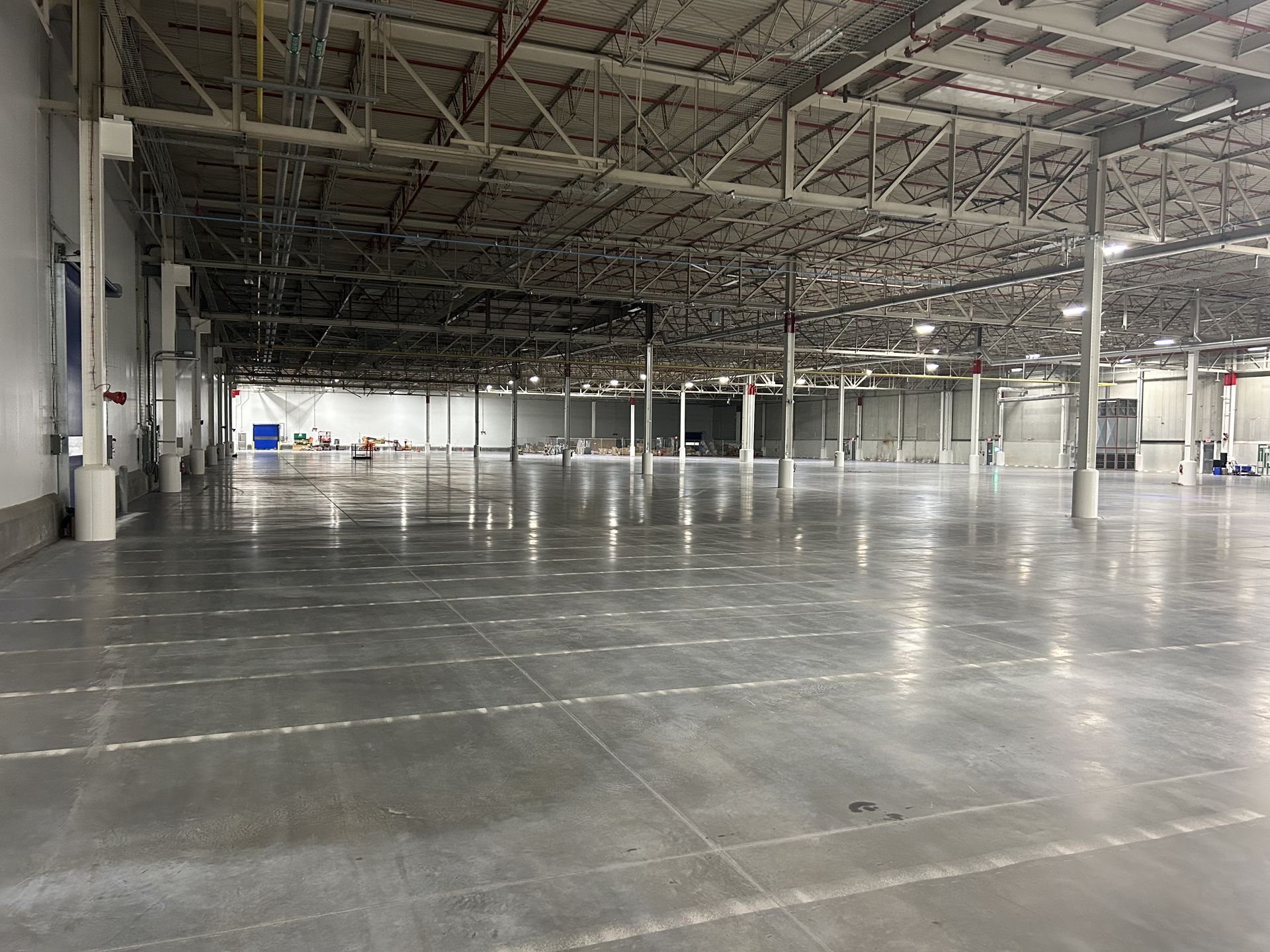 An empty warehouse with a concrete floor and ceiling.