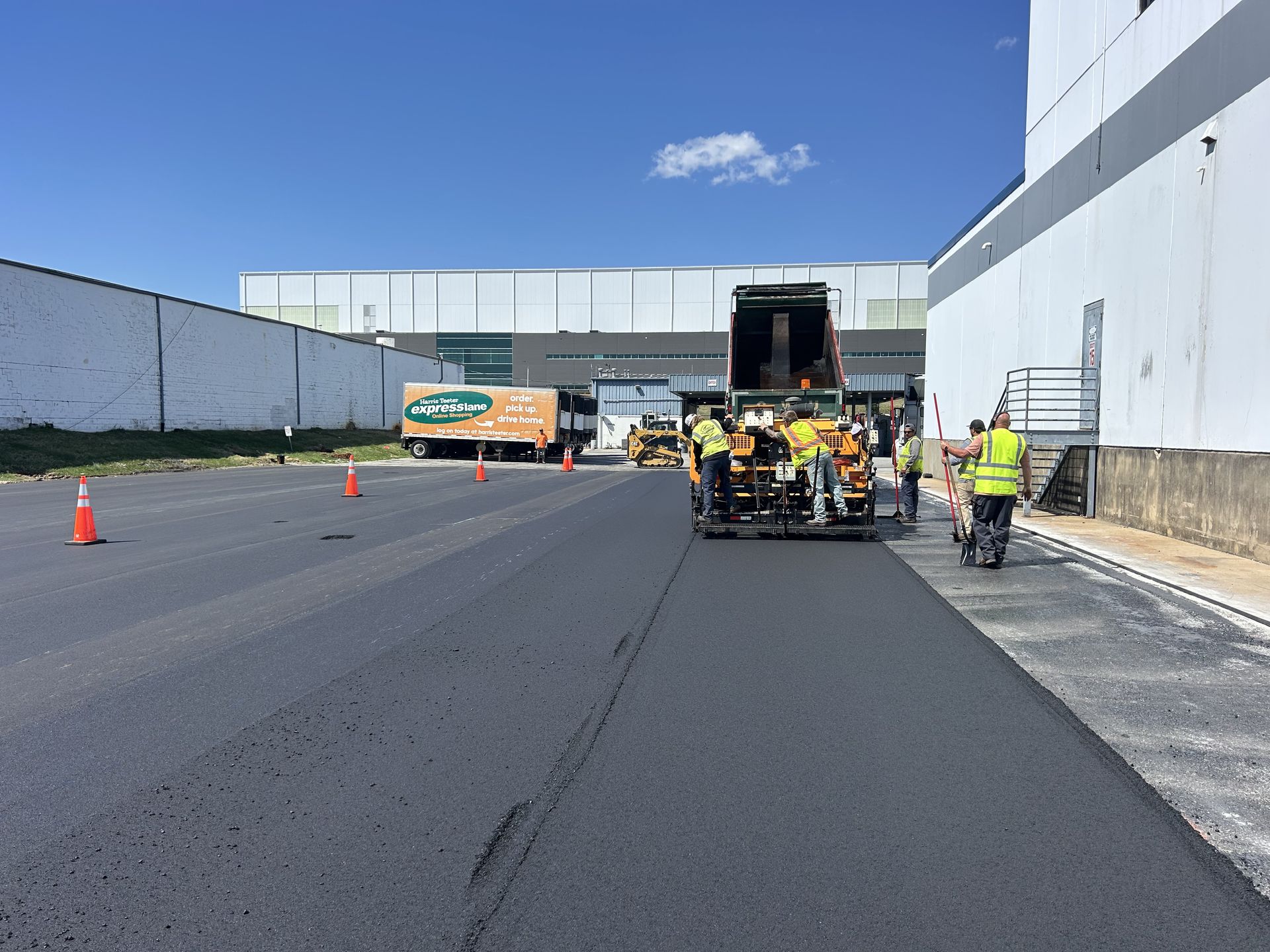 A group of people are working on a road in front of a building.