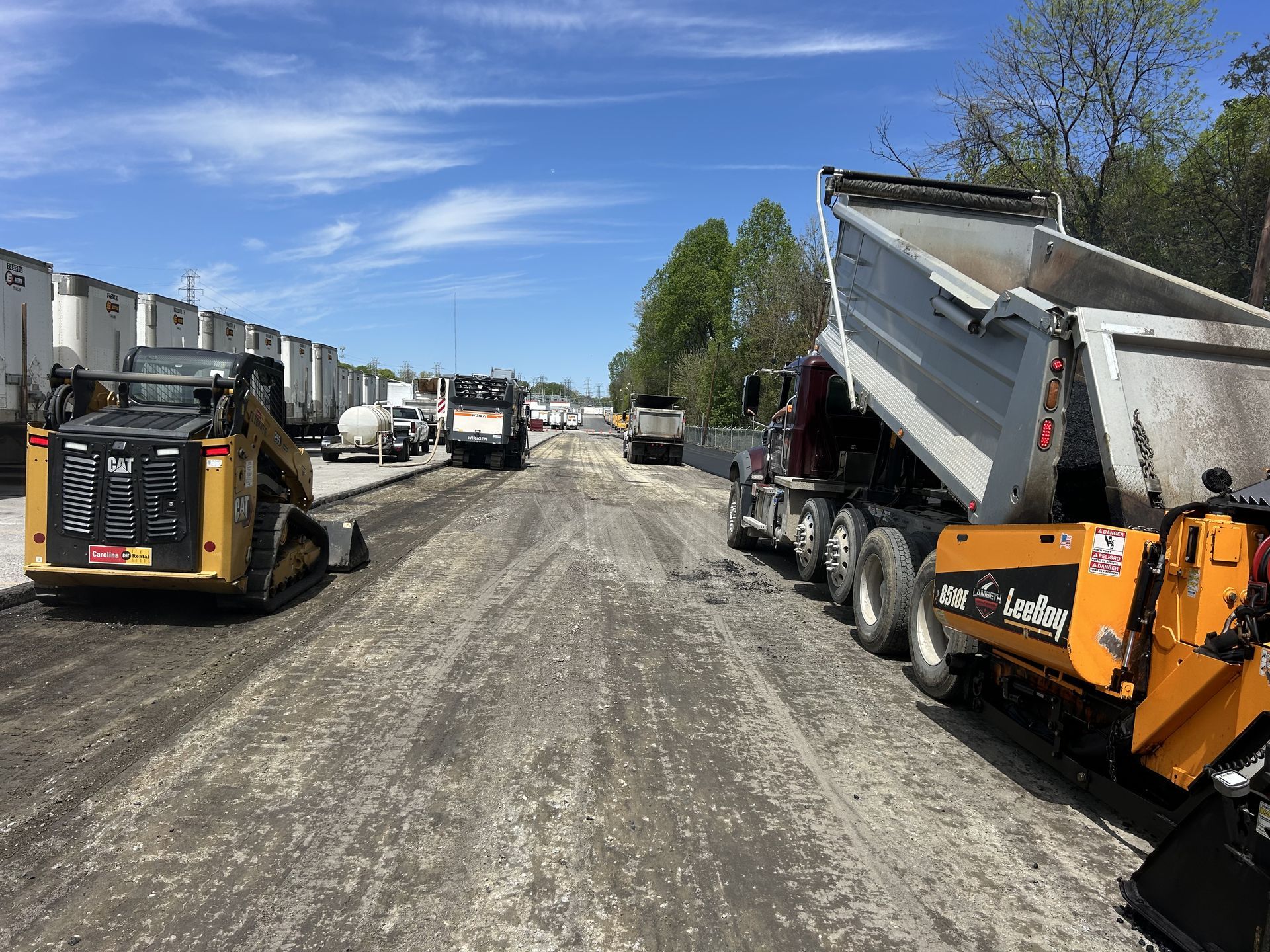 A dump truck is being loaded with dirt on a construction site.