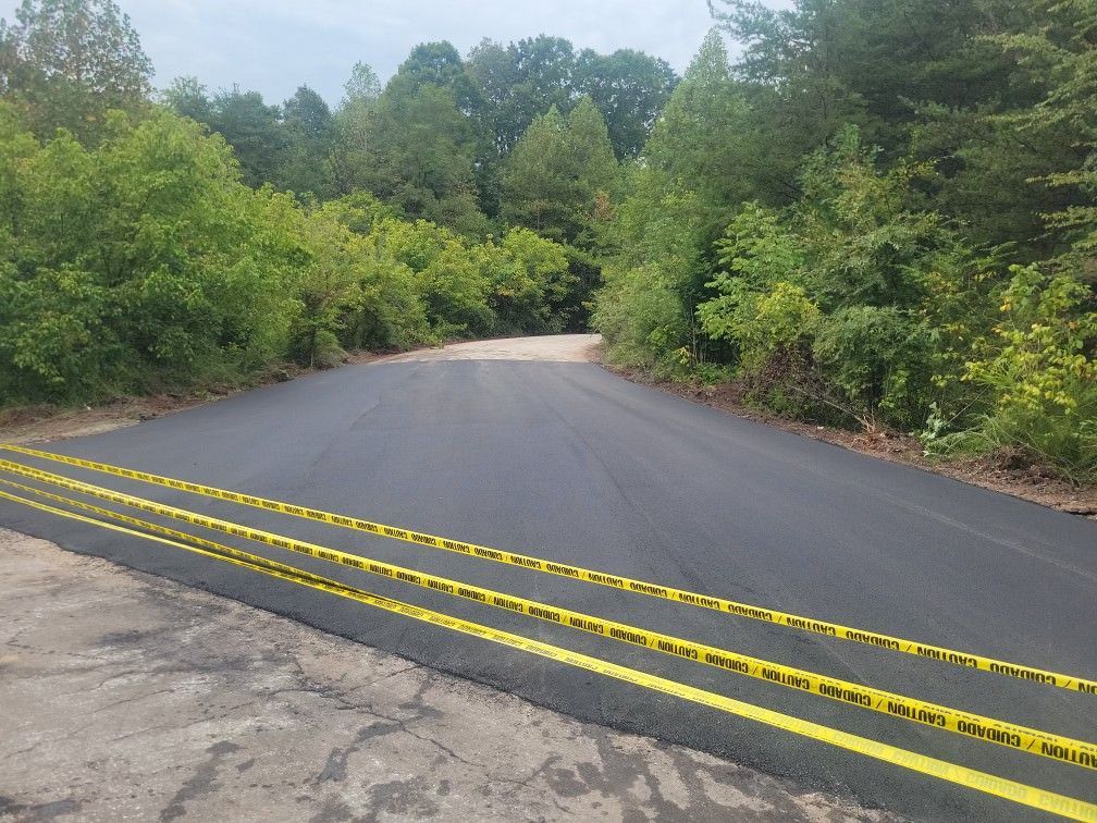 a road with yellow lines on it is surrounded by trees