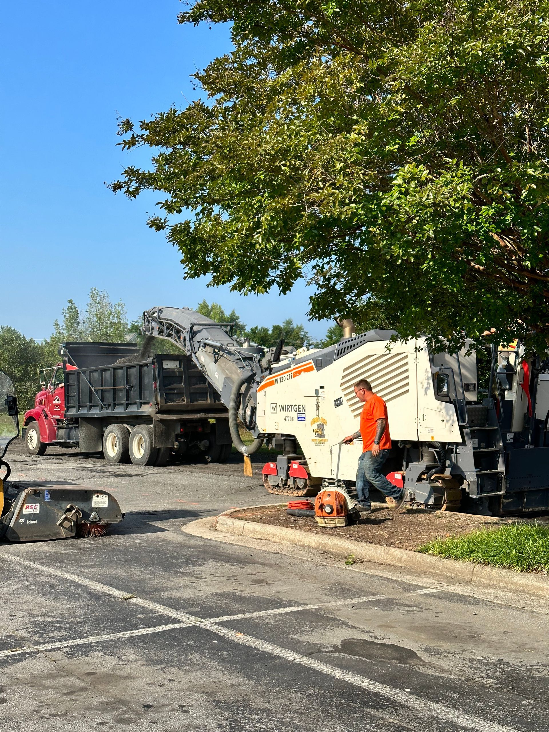 a man is standing next to a machine in a parking lot