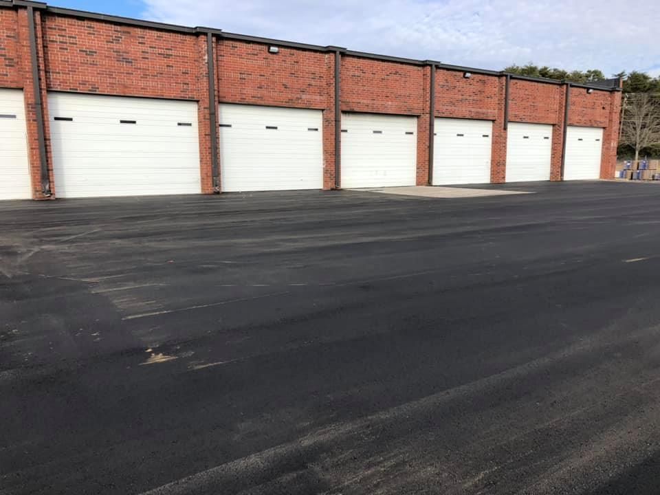 a row of garage doors are lined up in front of a brick building