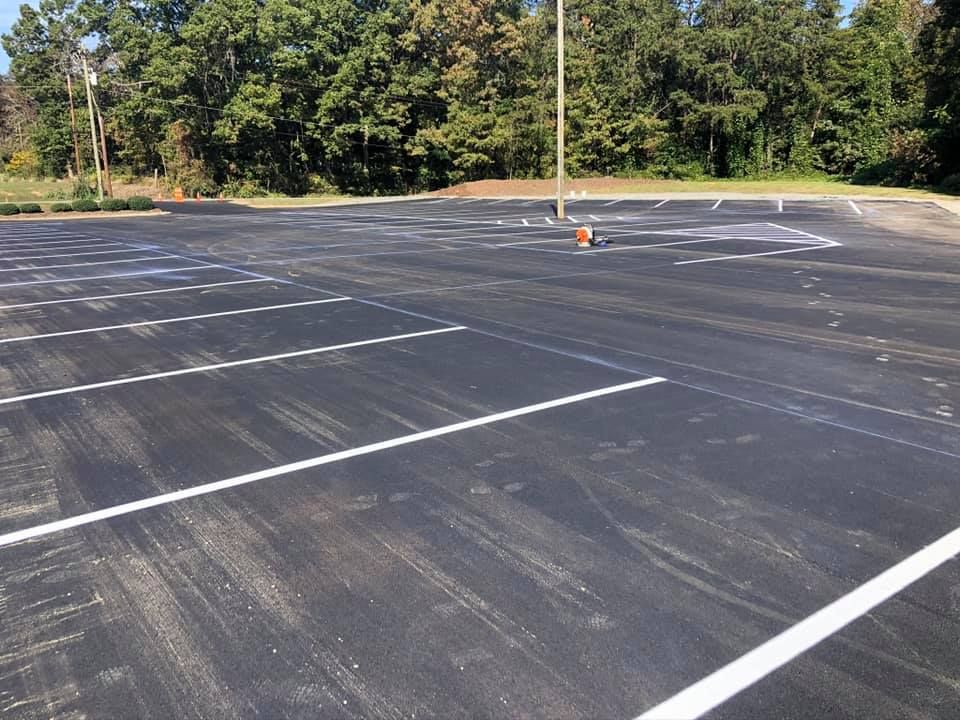 a parking lot with white lines and trees in the background