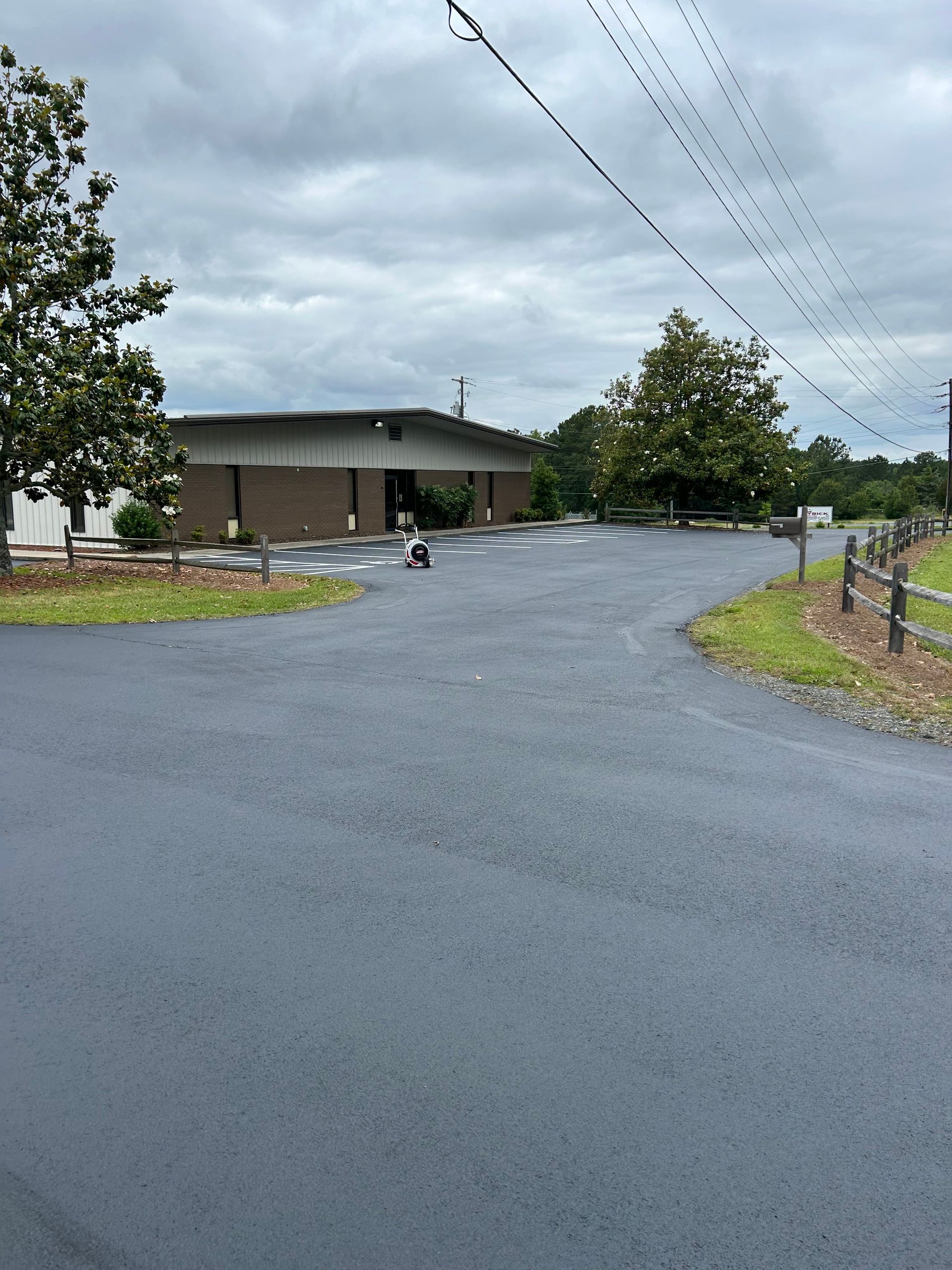a road with a building in the background on a cloudy day