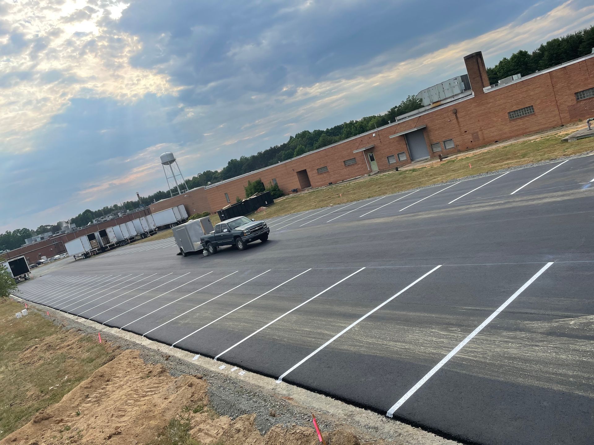 a truck is driving down a parking lot in front of a large building