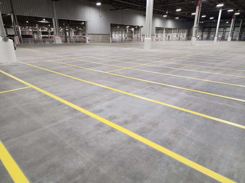a large empty warehouse with yellow lines on the floor