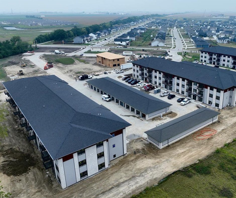 An aerial view of a building under construction with cars parked in front of it