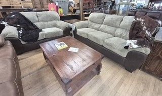 Living room set with two gray sofas and a wooden coffee table on a hardwood floor.