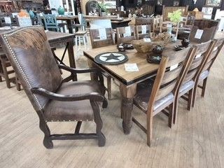 Rustic dining table with six wooden chairs in a furniture showroom