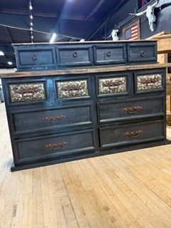 Dark wood dresser with mirrored drawers in a store showroom on a wood floor