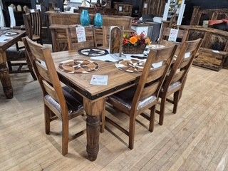 Wooden dining table set with chairs in a rustic furniture showroom