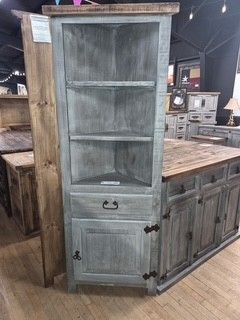 Weathered gray hutch cabinet with glass shelves and lower doors in a rustic kitchen display room