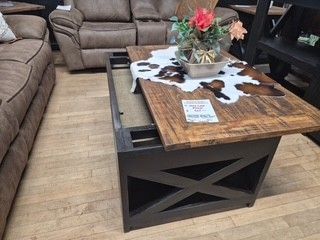 Living room with brown leather sofas and a rustic wood coffee table with cowhide decor and flowers