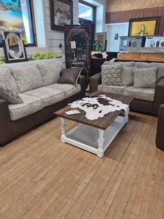 Living room with beige sofas, wicker coffee table, and bamboo floor mat