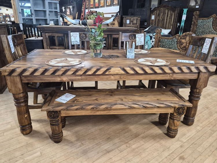 Rustic wooden dining table and bench in a furniture showroom.