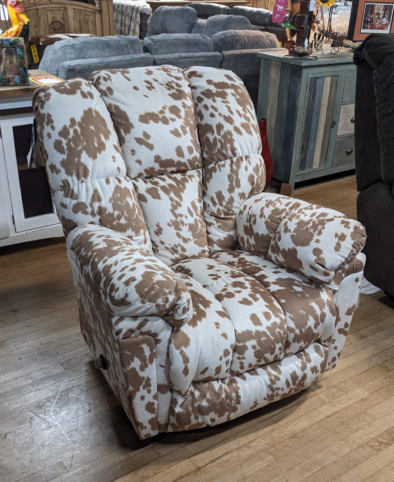 Cowhide-patterned recliner chair in a furniture store.