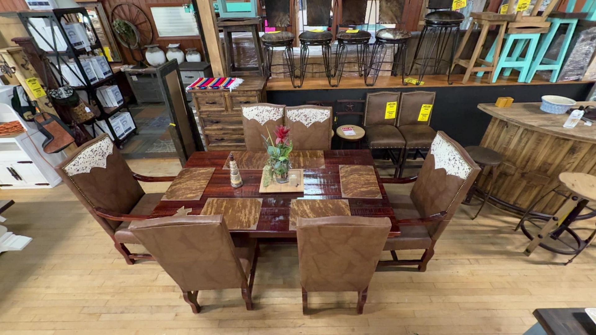 Dining set: Wooden table with six leather chairs, shop interior.