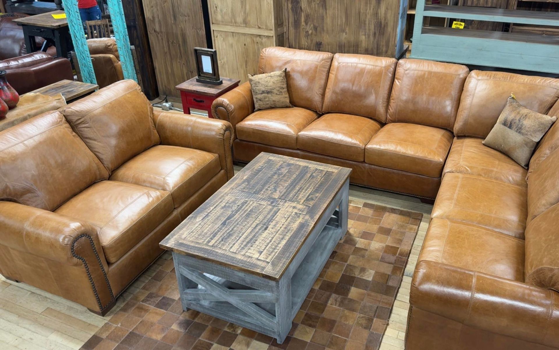 Leather sectional sofa and armchair with wooden coffee table in a furniture store.
