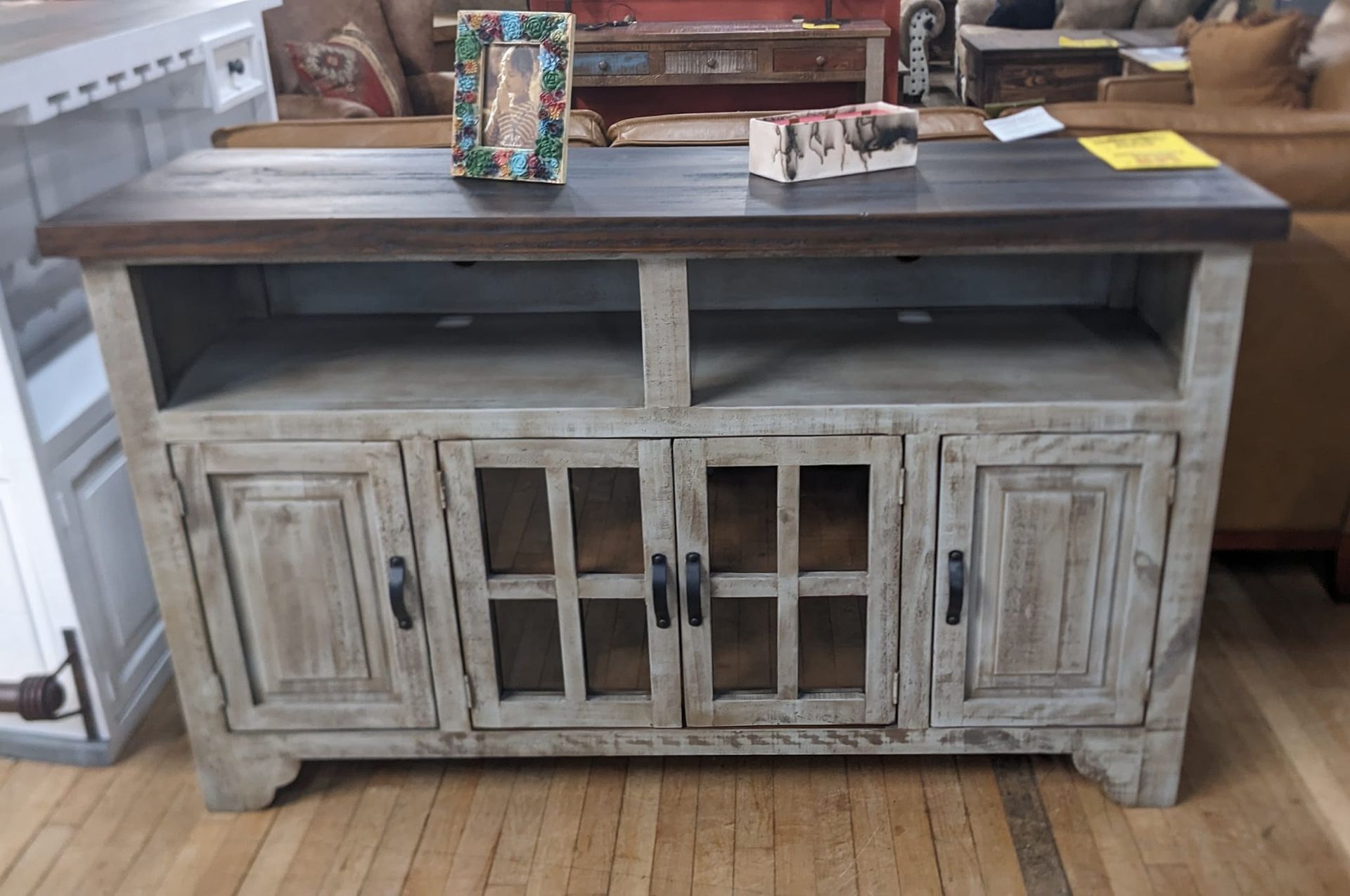 Rustic wood TV stand with shelves and glass-paned doors.