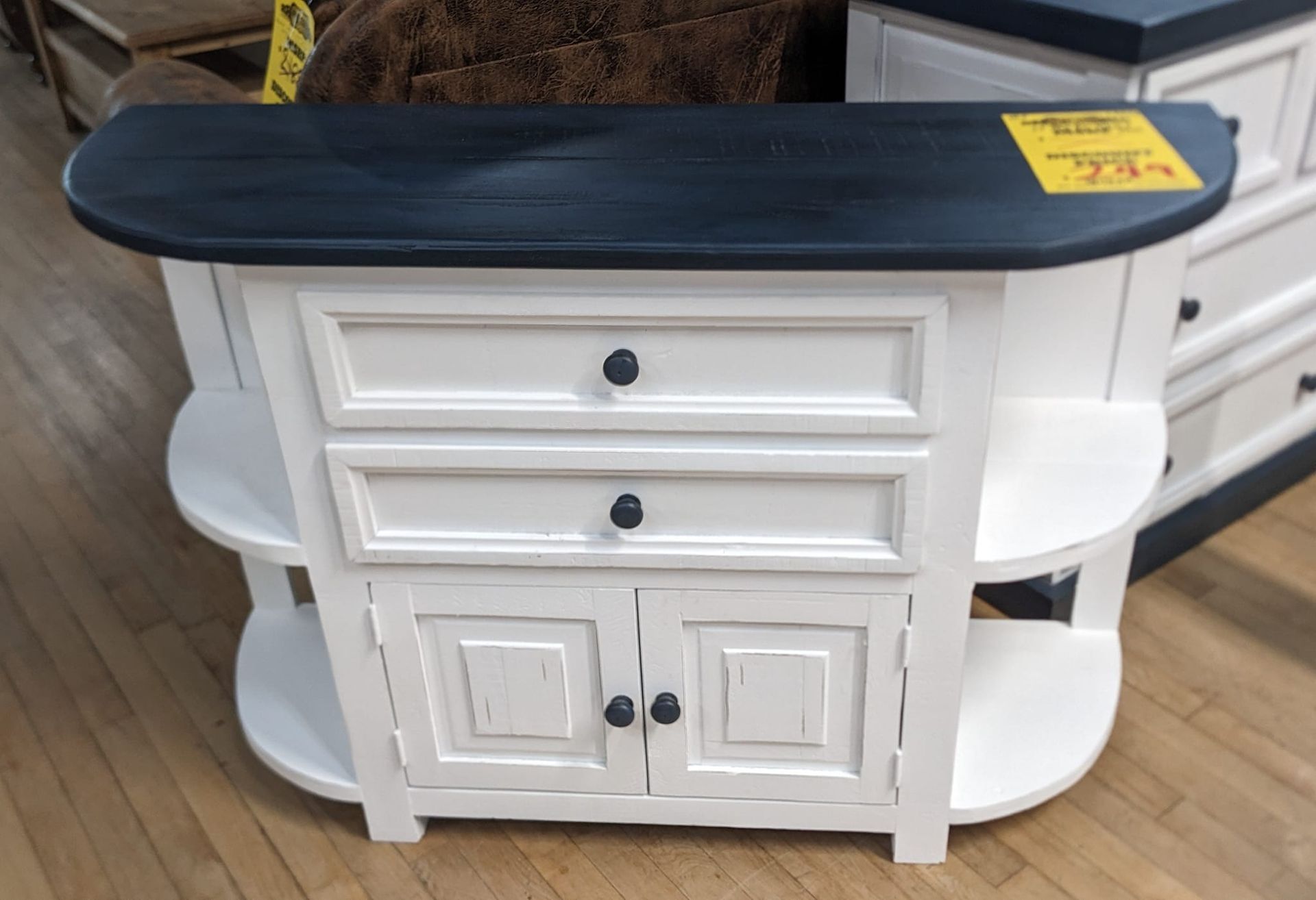 White and dark-topped console with two drawers, two shelves, and two doors with black handles.