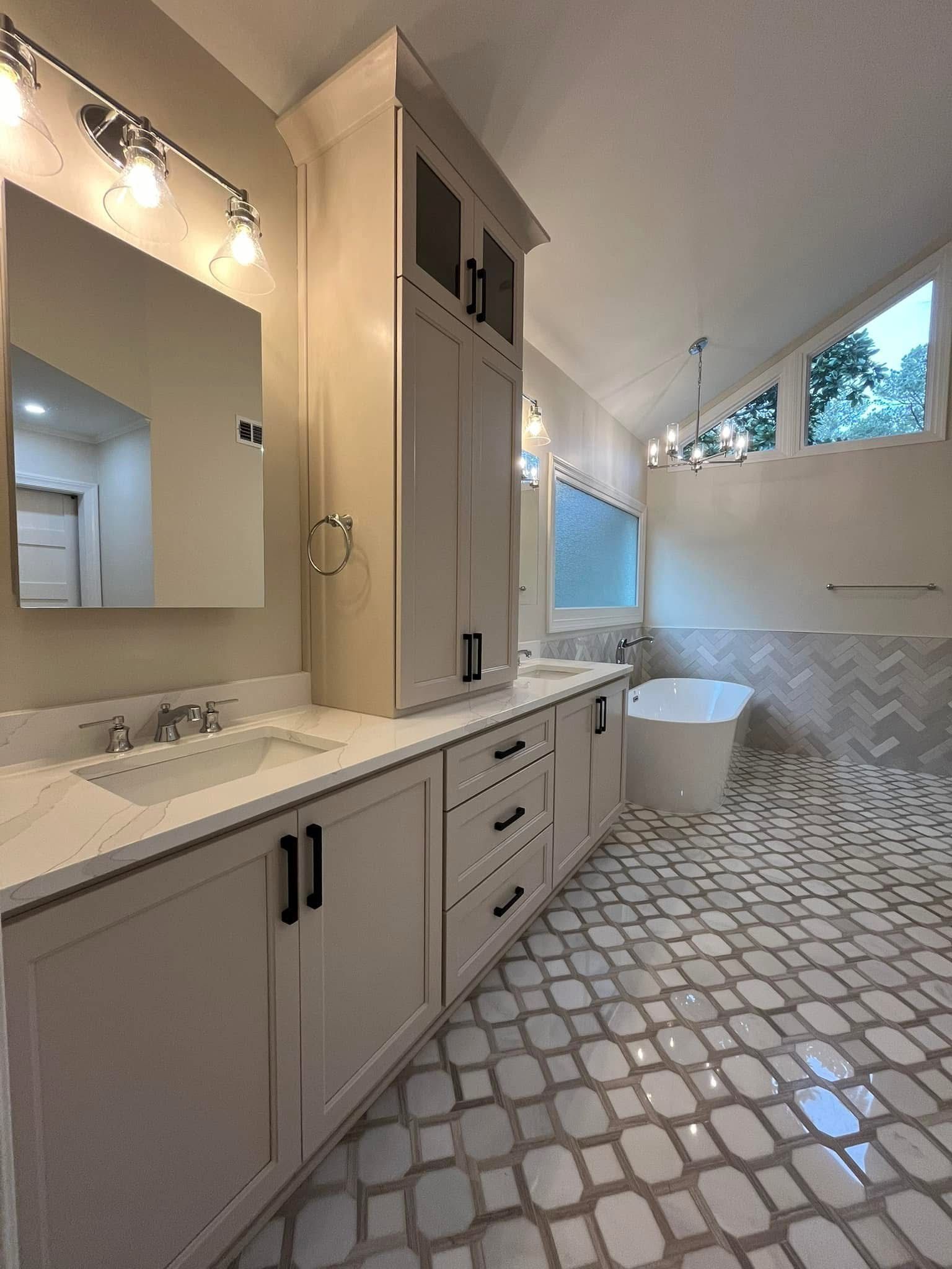 Bathroom with white cabinets, stone floor, and a soaking tub.