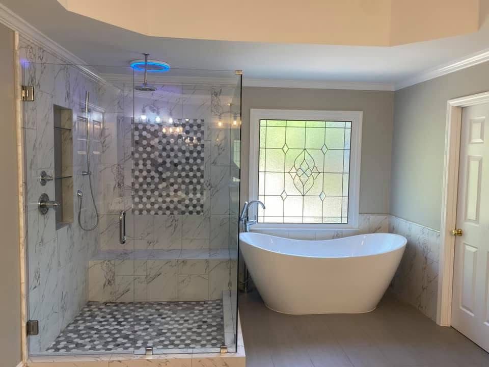 Modern bathroom with glass shower, soaking tub, and stained glass window.