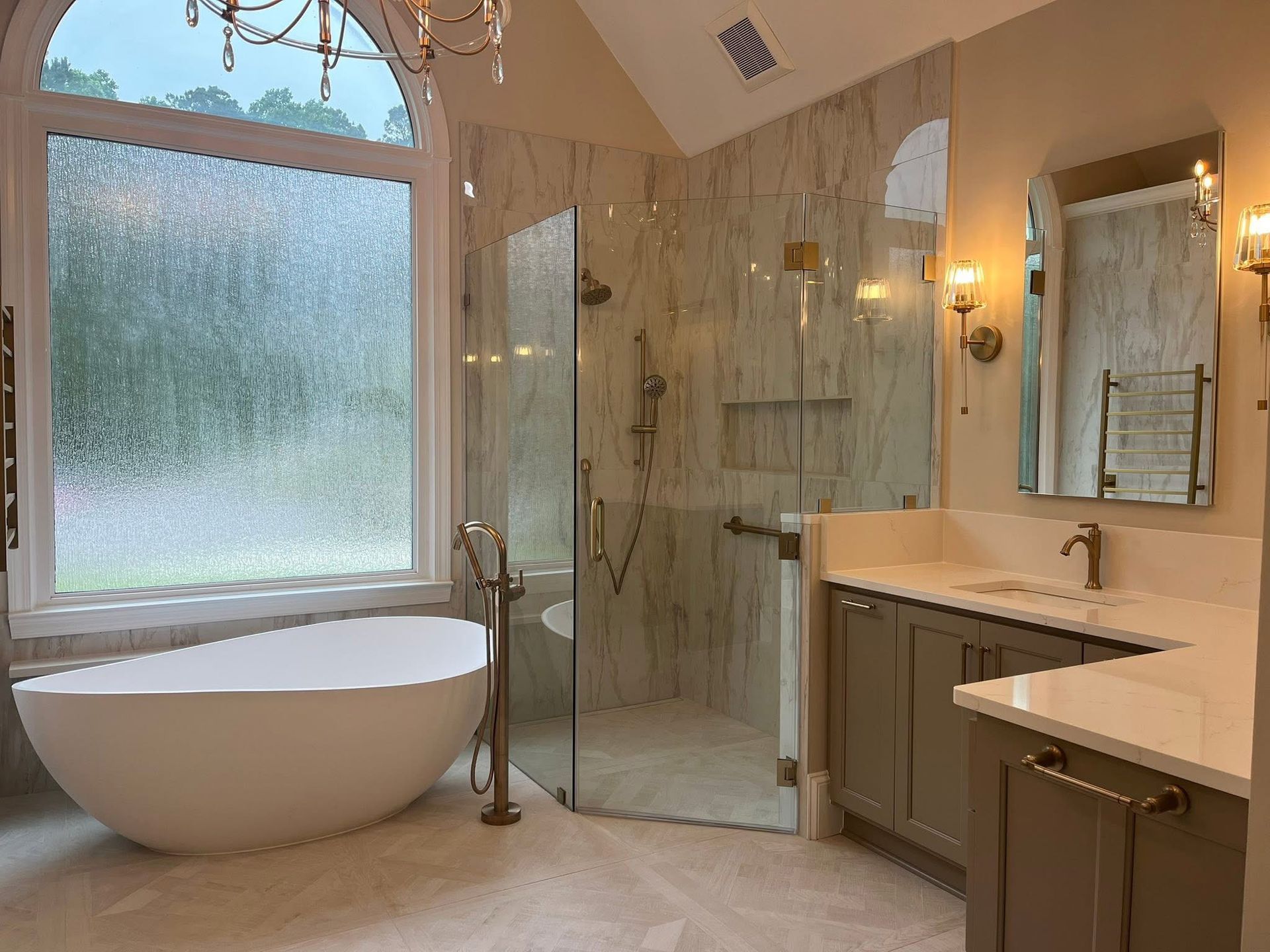 Luxurious bathroom with a freestanding tub, glass shower, and vanity.