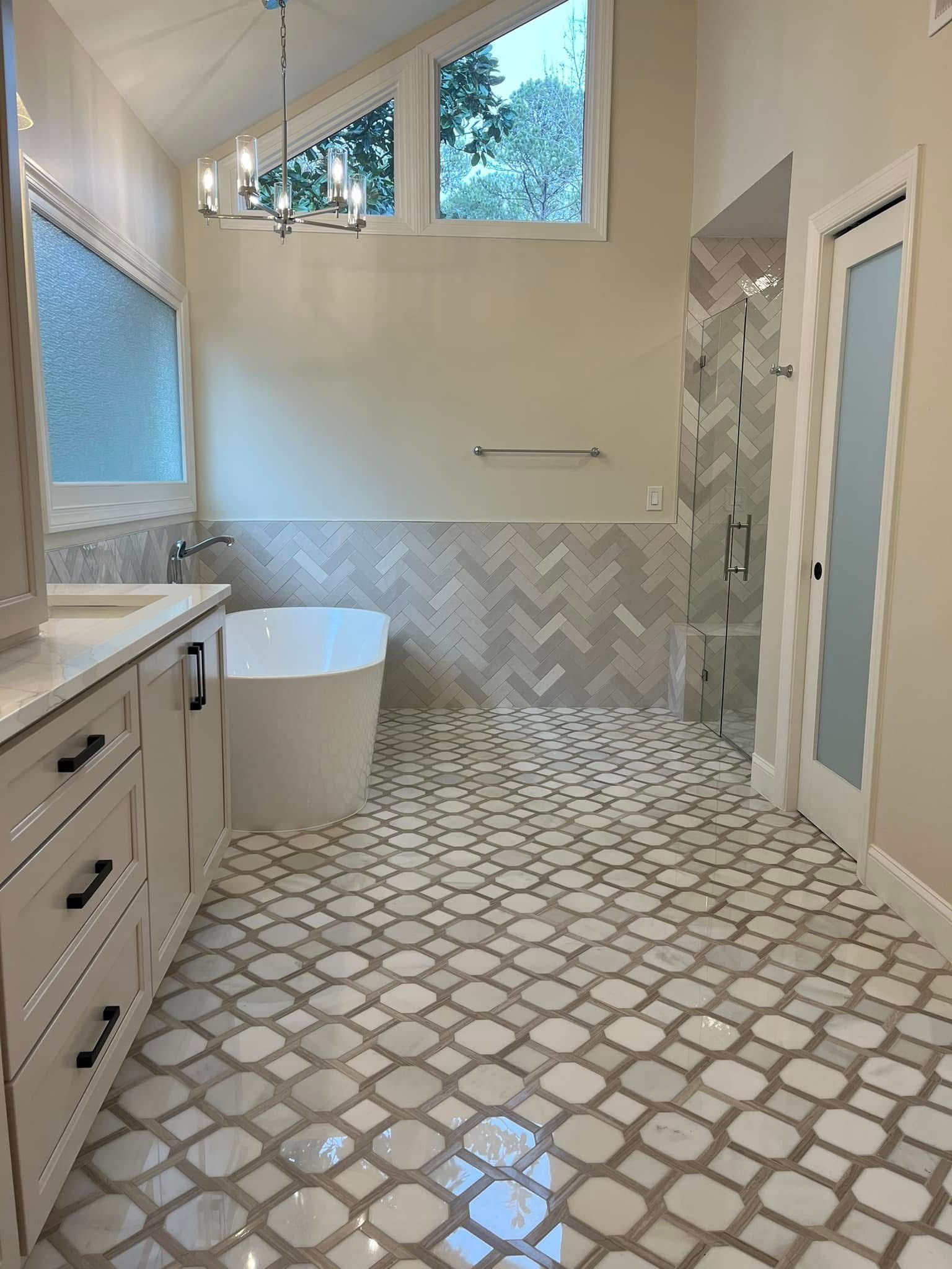 Bathroom with white vanity, freestanding tub, patterned tile floor, and a walk-in shower.