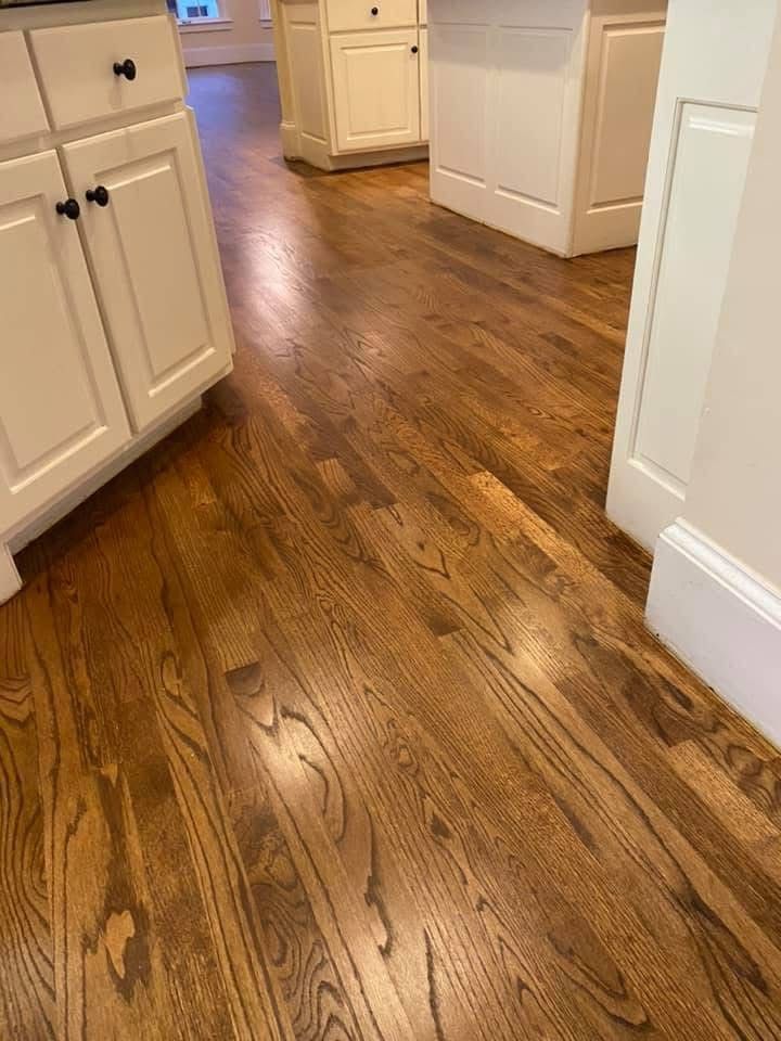 Hardwood floor in a kitchen with white cabinets.