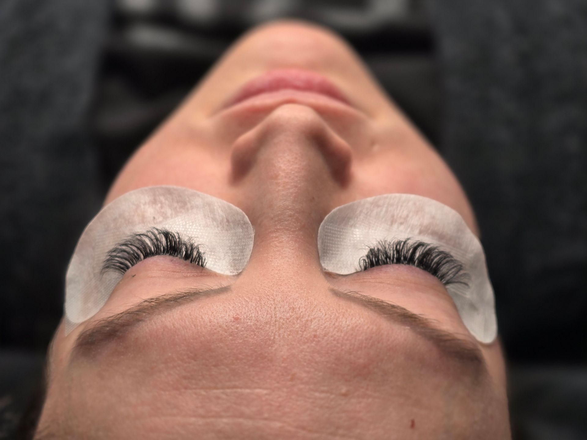 A close up of a woman 's face with false eyelashes on her eyes.