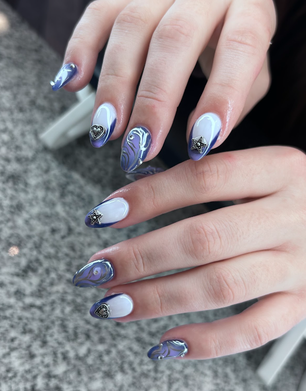 A close up of a woman 's hand with purple and white nails.