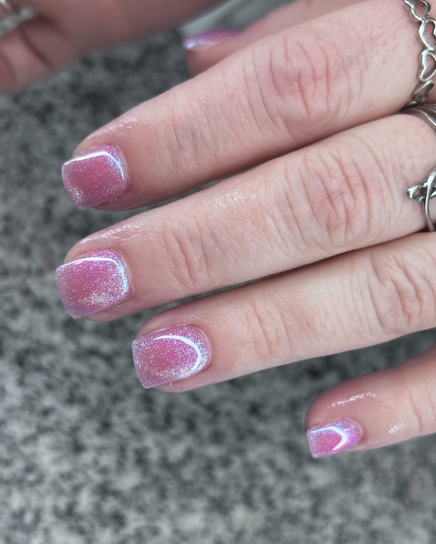A close up of a woman 's hand with pink nails.