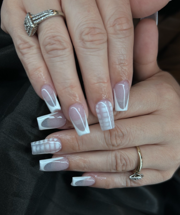 A woman with long nails and a ring on her finger.