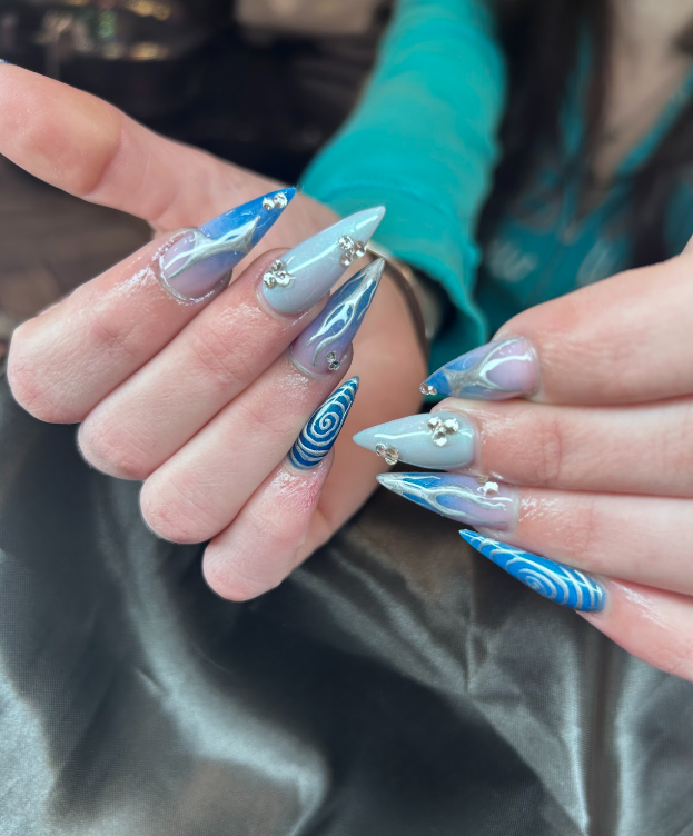 A close up of a person 's nails with a blue and purple design.