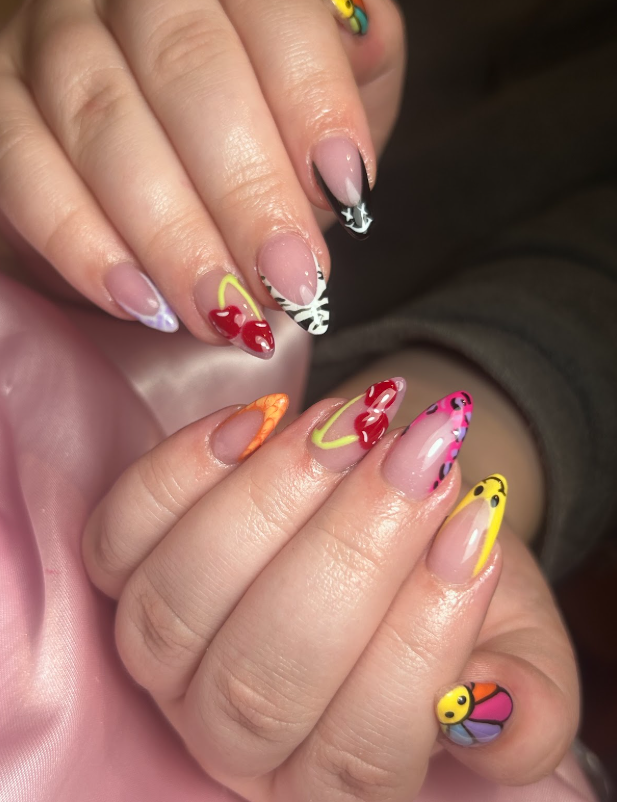 A close up of a person 's nails with different designs on them