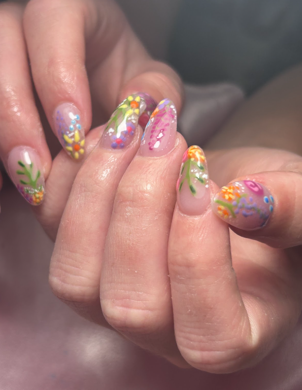 A close up of a person 's nails with flowers on them.