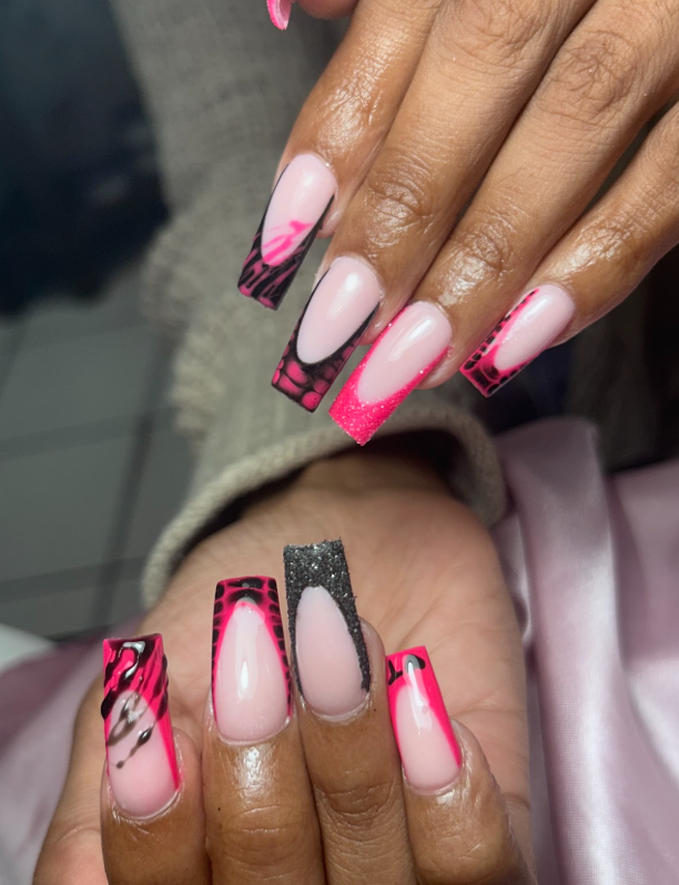 A close up of a person 's nails with a pink and black design.