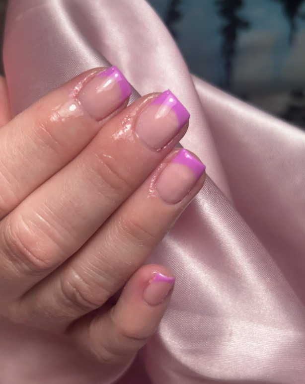 A close up of a person 's nails with a pink french manicure.