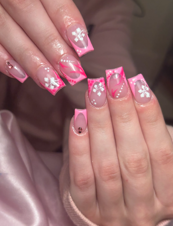 A close up of a woman 's nails with pink and white designs.