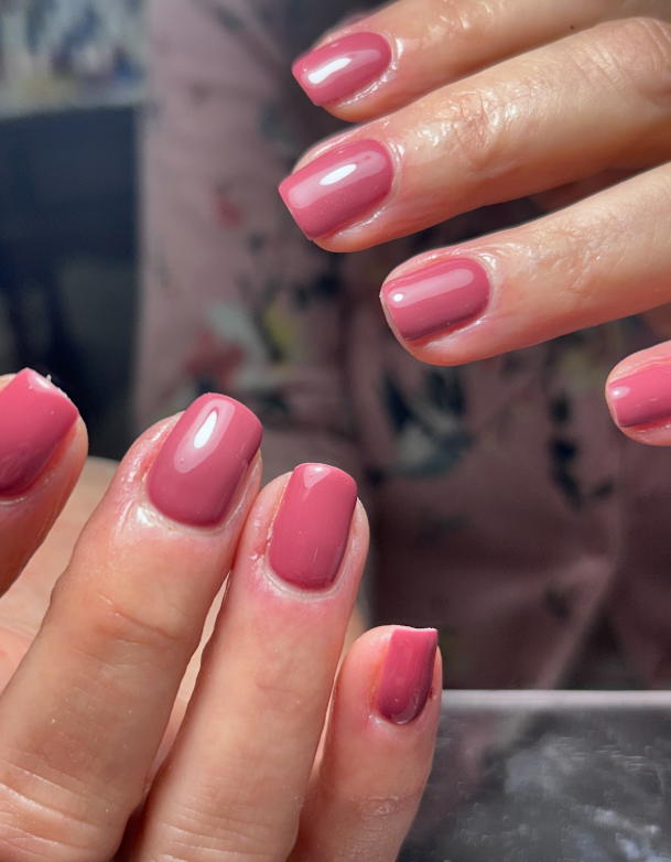 A close up of a woman 's pink nails.